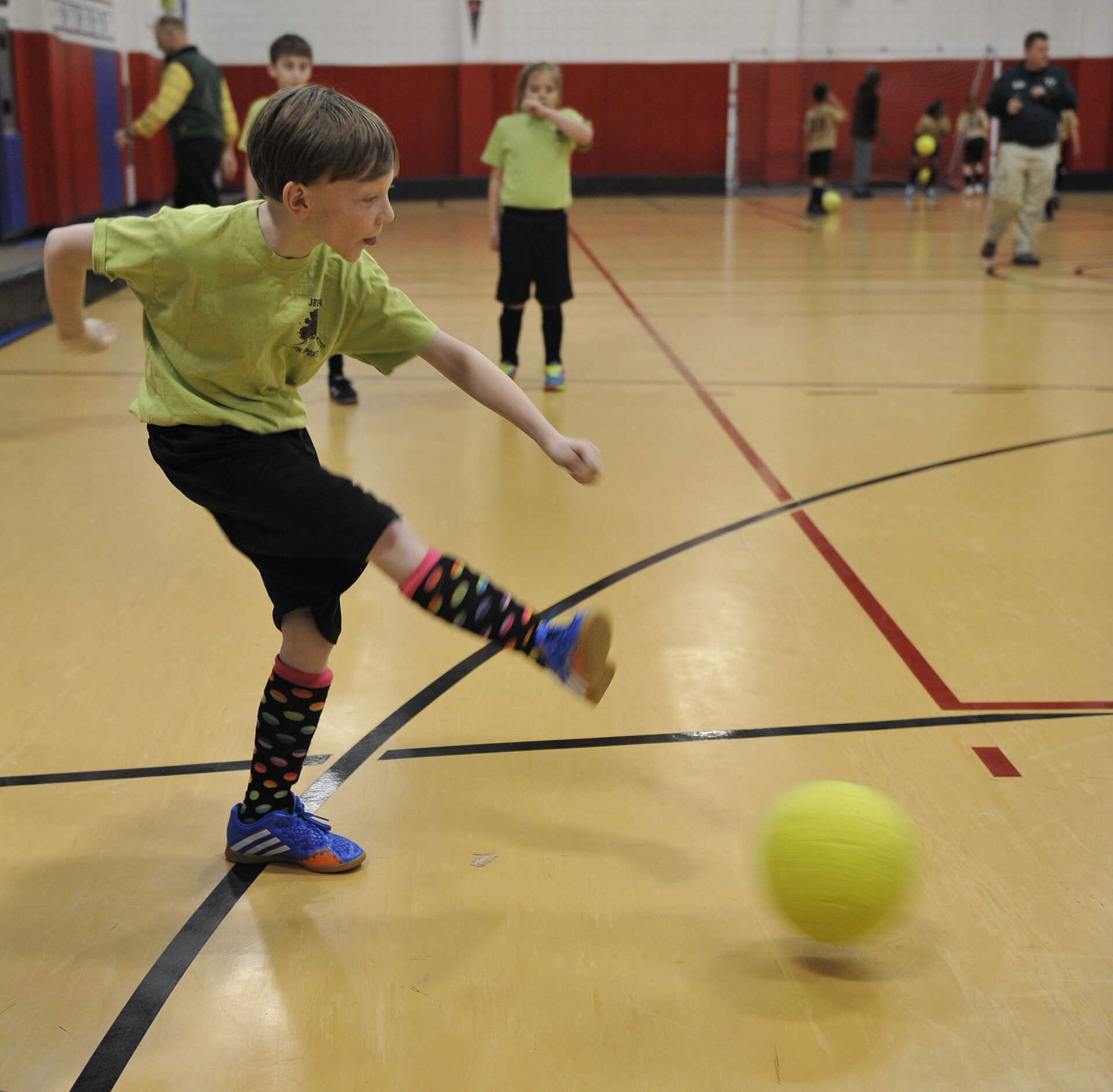 Young football player striking a ball during practice